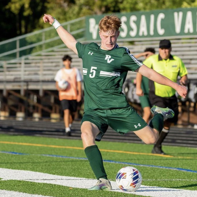  Senior Mike Post kicks a soccer ball during a game